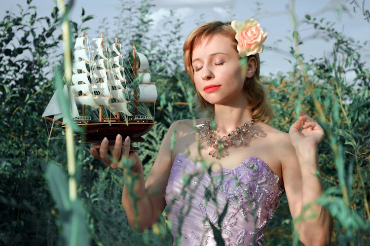 Young Woman With Ship Model In Garden