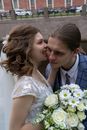 Carefree bride biting cheek of stylish groom on wedding day