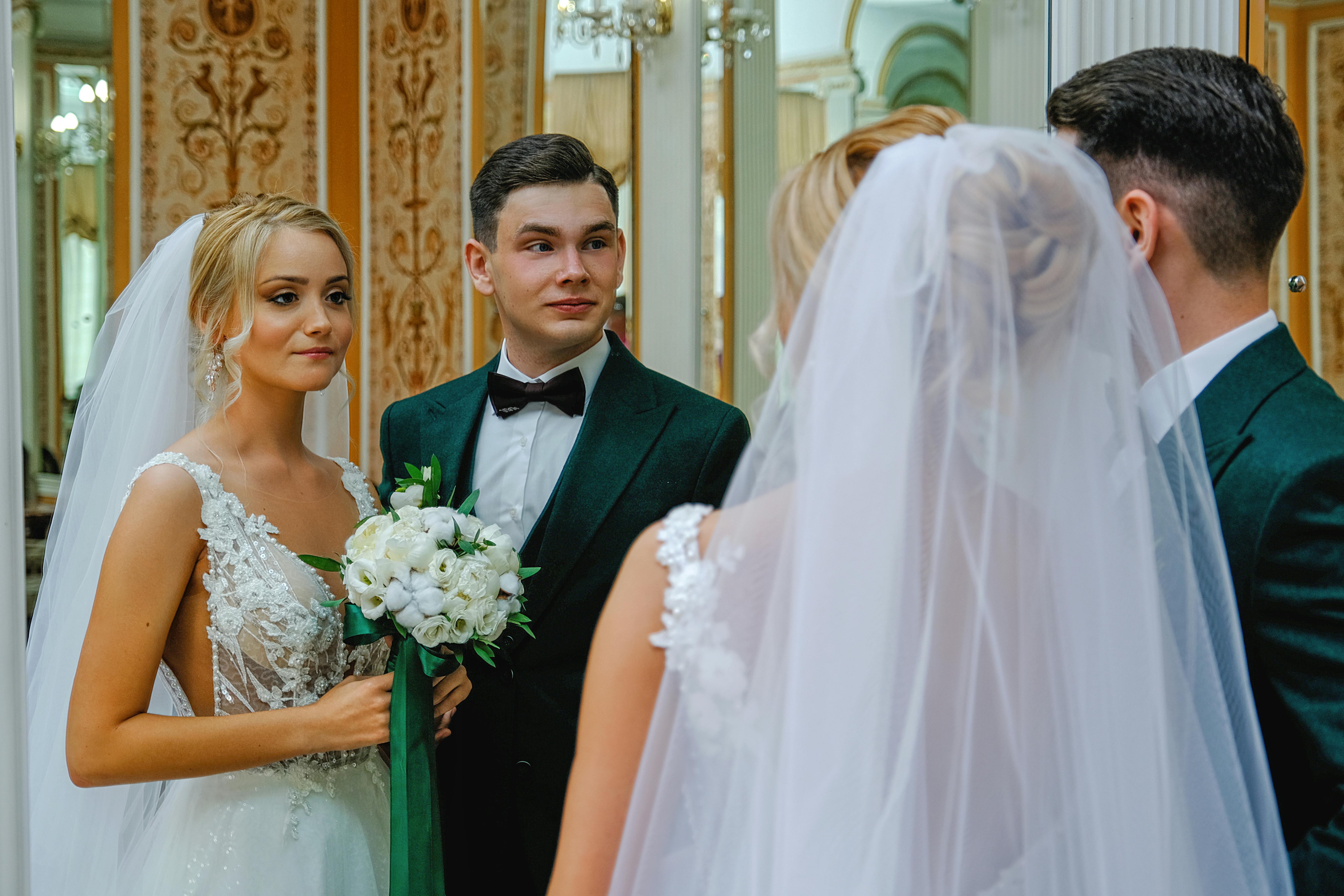 happy newlywed couple standing in front of mirror