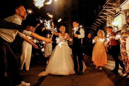 Cheerful young just married couple having fun with guests