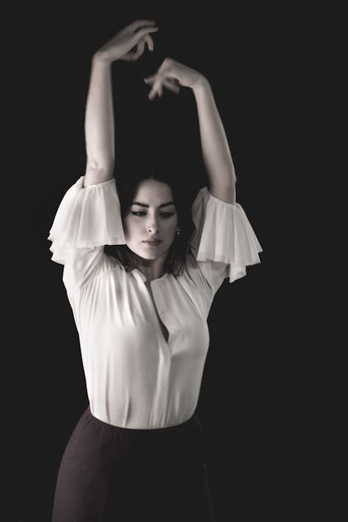 A Woman in White Long Sleeves Raising Her Hands