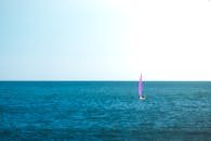 一艘充满活力的紫色帆船在地中海宁静的水域中航行