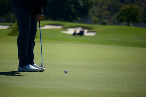 Person Holding Putter Playing Golf