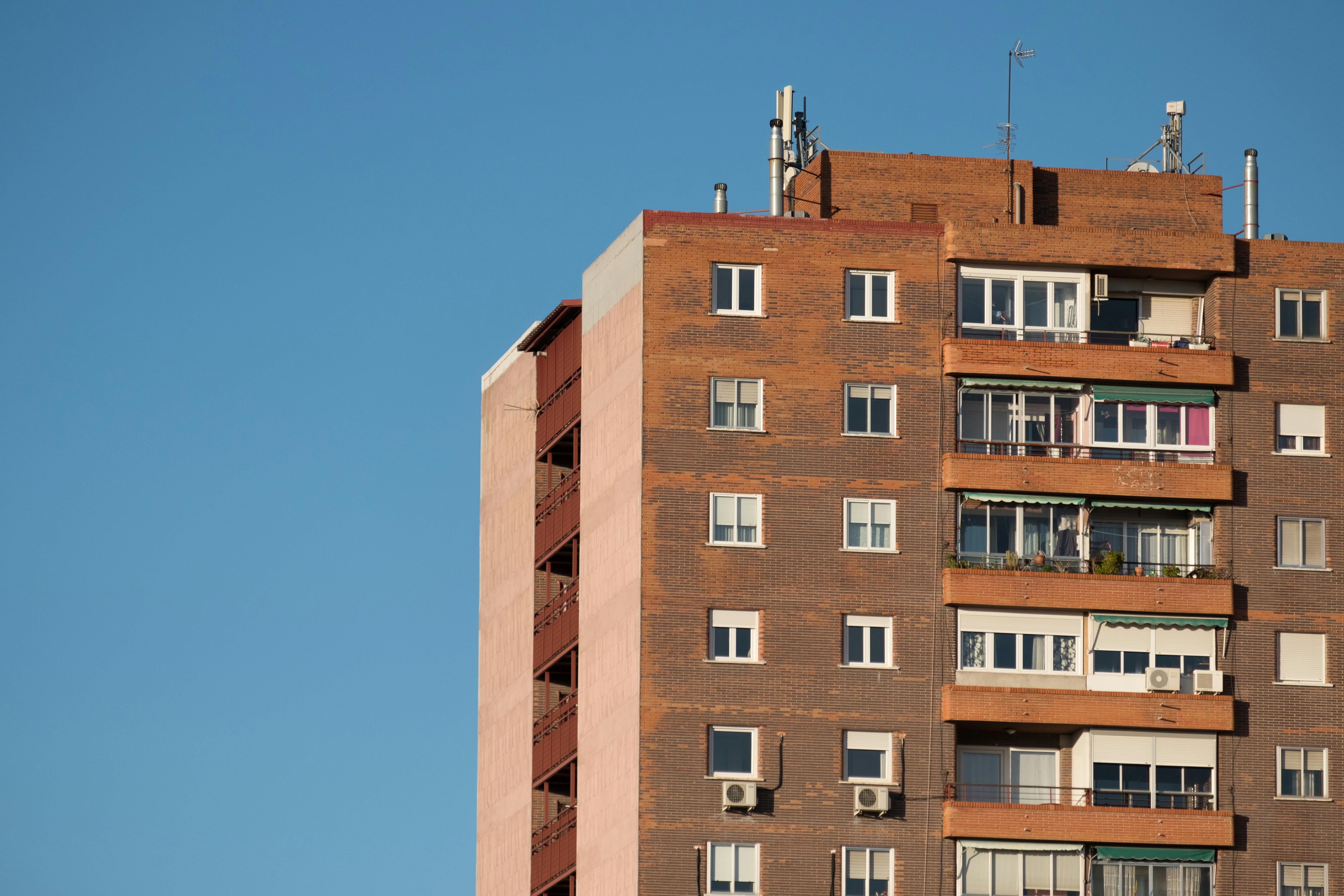 Facade of a modern apartment building against a clear blue sky in Madrid, Spain.