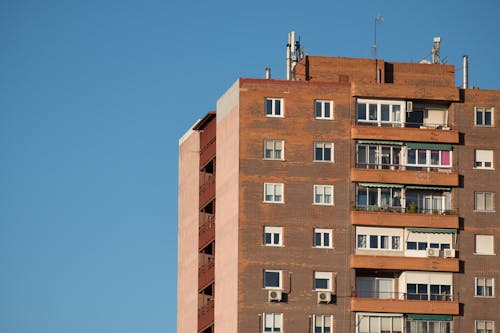 açık mavi gökyüzü, apartman binası, camlar içeren Ücretsiz stok fotoğraf