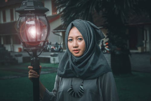 Woman Wearing Hijab Holding Street Lamp
