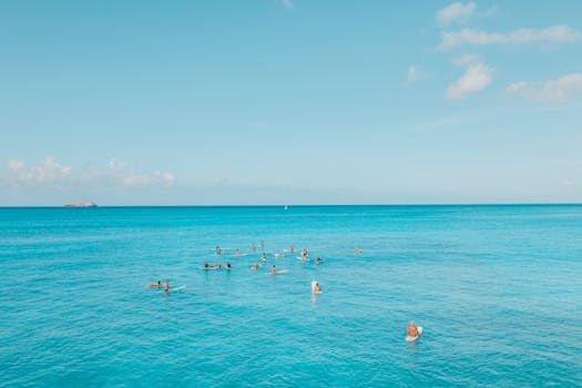 在夏威夷，一群冲浪者正享受着清澈的蓝色海洋和晴朗的天空，这完美的热带天堂场景