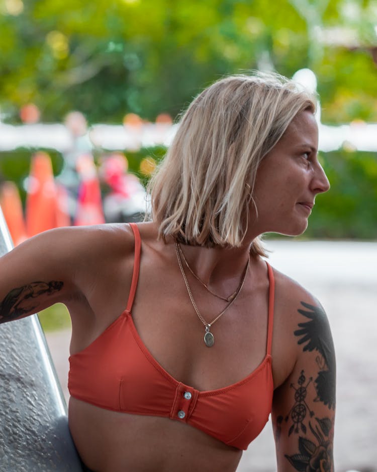 Woman In Red Bikini Top With Tattoo On Her Left Arm