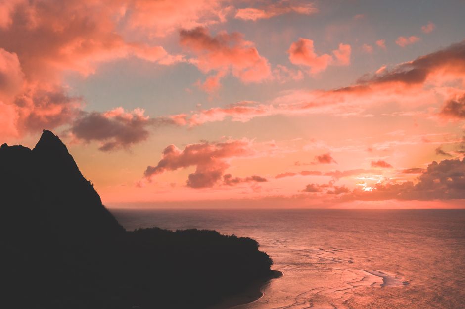 Private Kauaʻi Experience: Doors-Off ALL WINDOW SEATS - Breathtaking sunset over Hawaiian coastline with vibrant sky and ocean view.