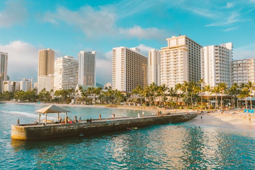 Experience a vibrant day at Waikiki Beach with lively beachgoers and stunning skyline.