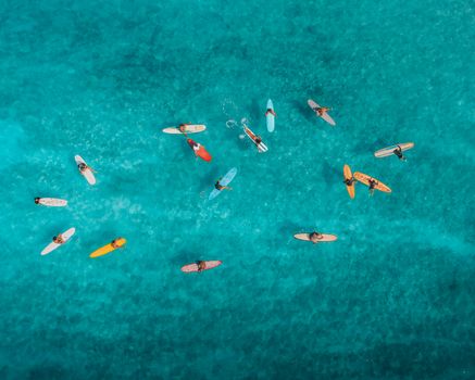生动鸟瞰图：夏威夷蓝色海洋中，冲浪者立于彩色冲浪板之上