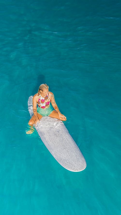 Free Woman in Pink and White Bikini Sitting on Gray Rock in the Pool Stock Photo