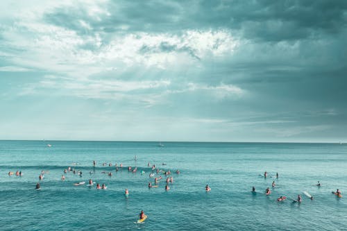 Photo of People Surfing Under a Cloudy Sky