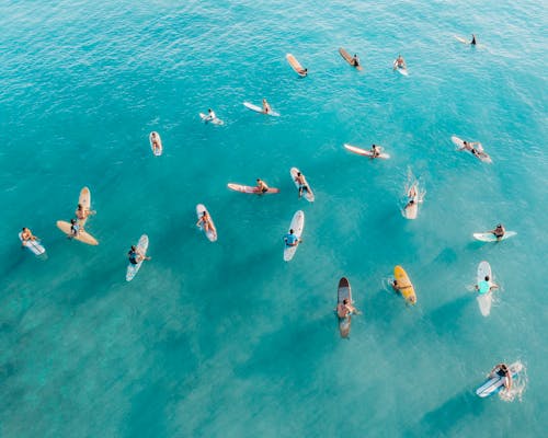 Free People Surfboarding on Sea Stock Photo