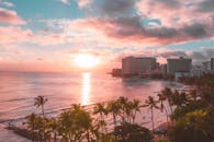 充满活力的热带海滨，种植着棕榈树，还有一个俯瞰温暖日落的度假村