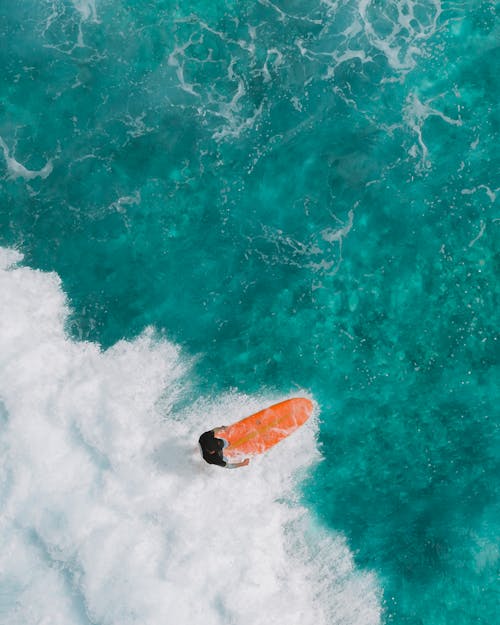 High-Angle Shot of a Person Surfboarding on Sea Waves