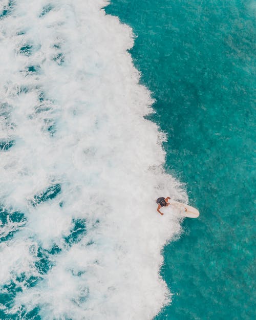 Free Drone Shot of a Person Surfboarding on Sea Waves Stock Photo