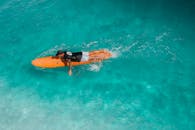 男子在热带海洋中划着冲浪板，捕捉夏季冒险的精髓