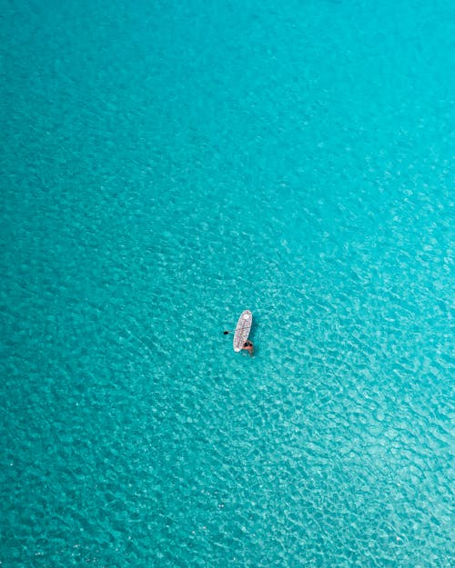 A Person with a Surfboard in the Sea