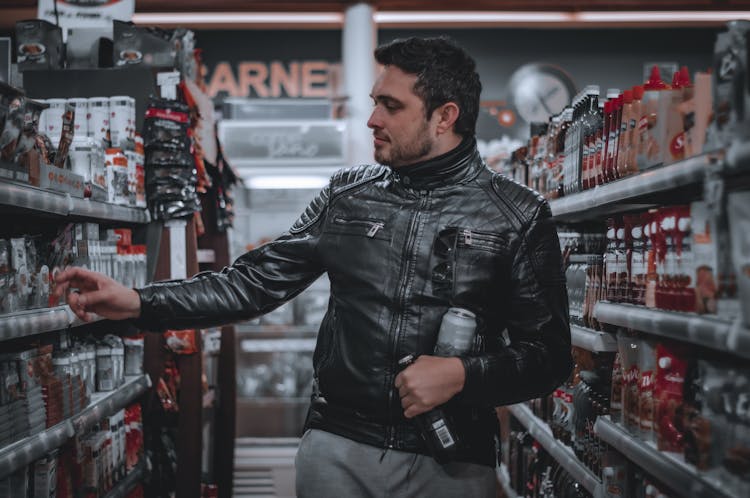 Brunette Man In Leather Jacket Shopping In Automotive Shop