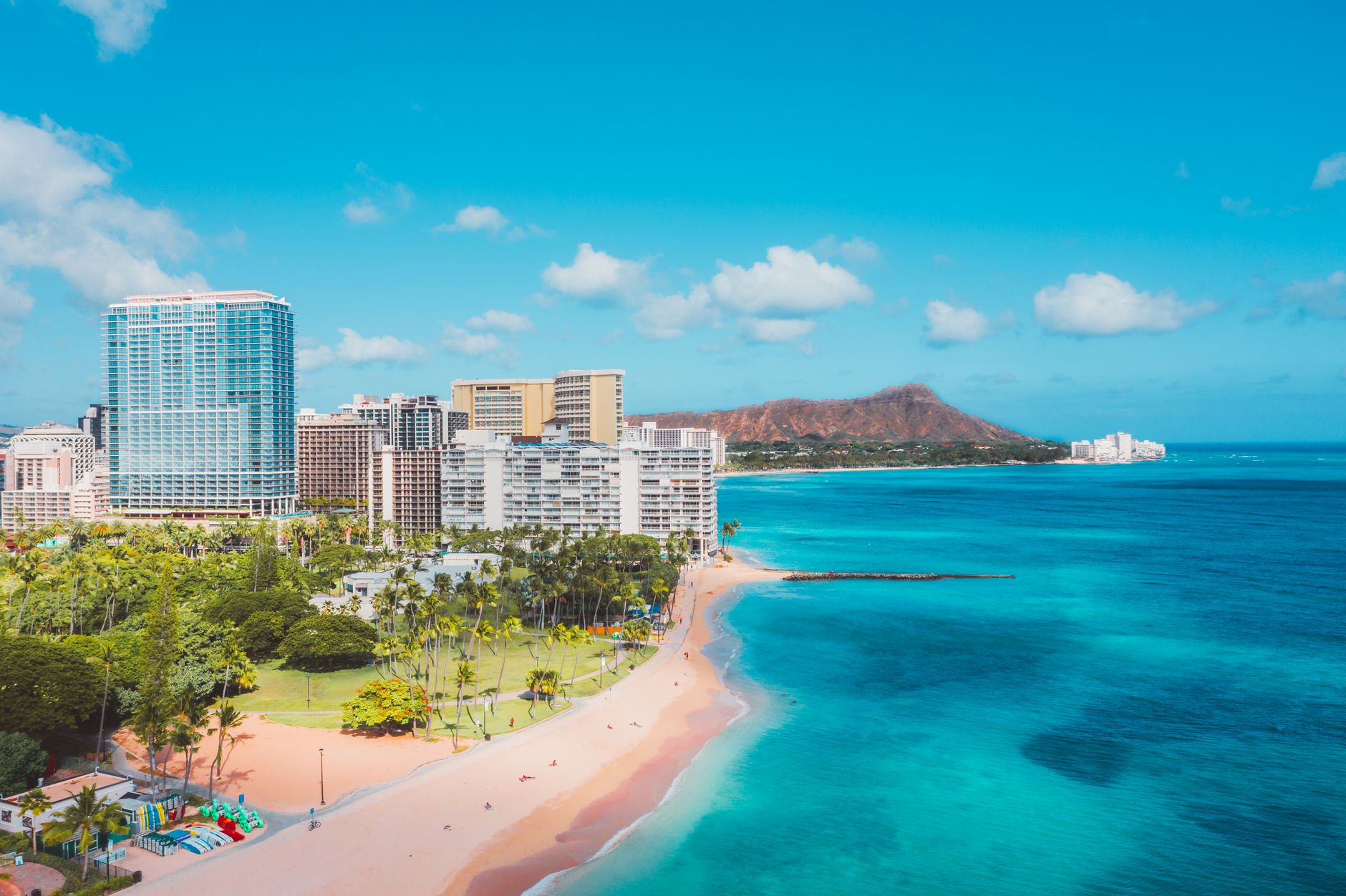 Photo by Jess Loiterton Stunning view of Waikiki Beach with Diamond Head in the background under a clear blue sky.
