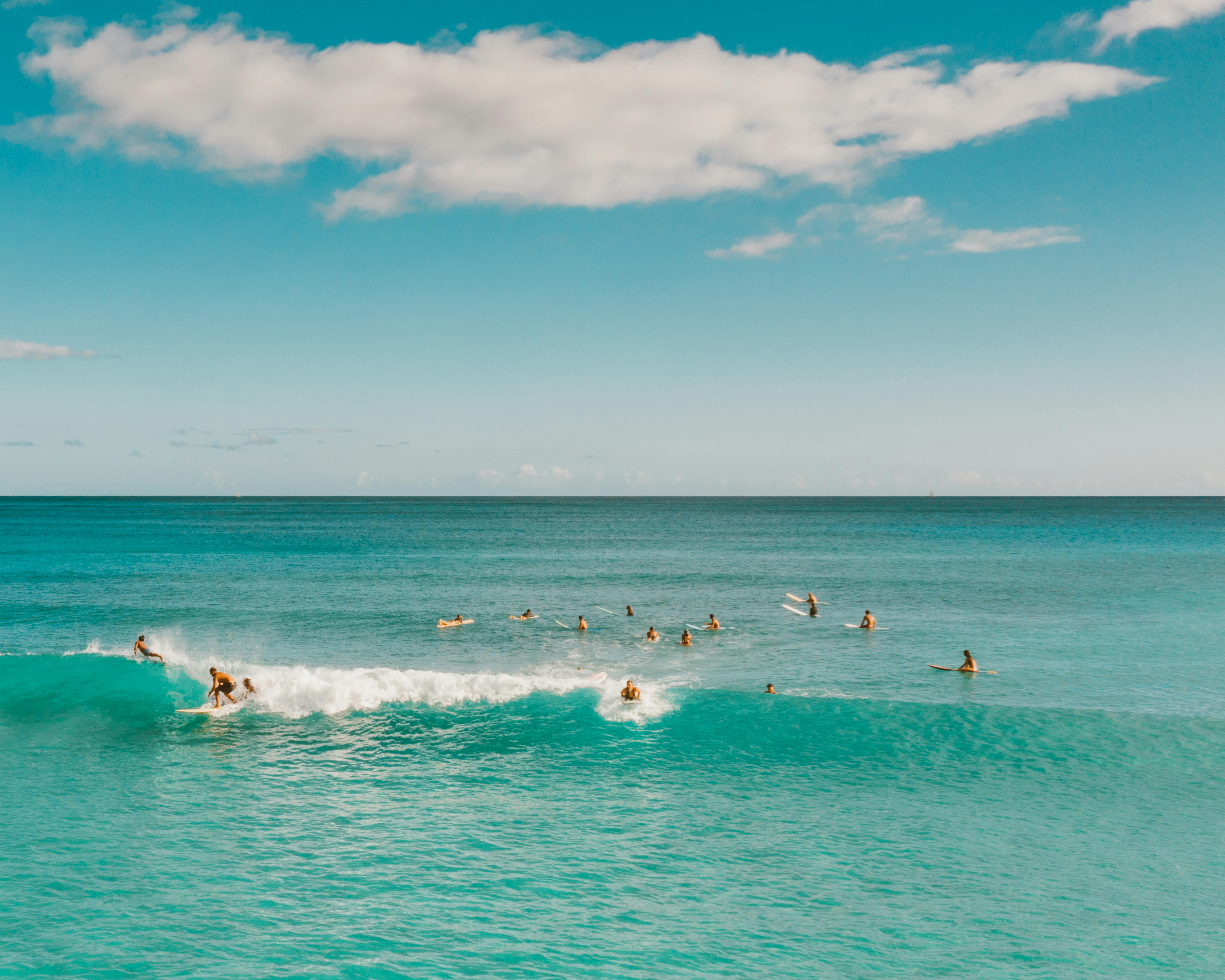 一群冲浪者在宁静的热带海洋上，迎着蓝天冲浪