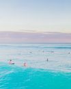 在晴朗的夏日天空下，人们在宁静的海景中游泳和冲浪