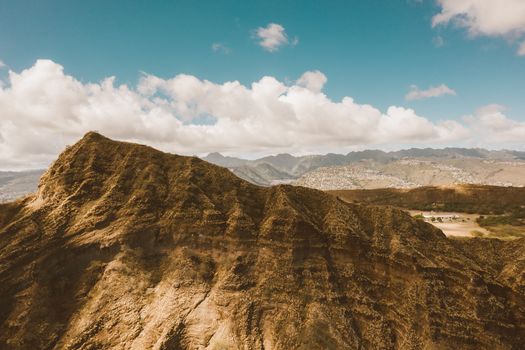 崎岖的山地景观映衬着鲜艳的蓝天和蓬松的云层，景色令人惊叹