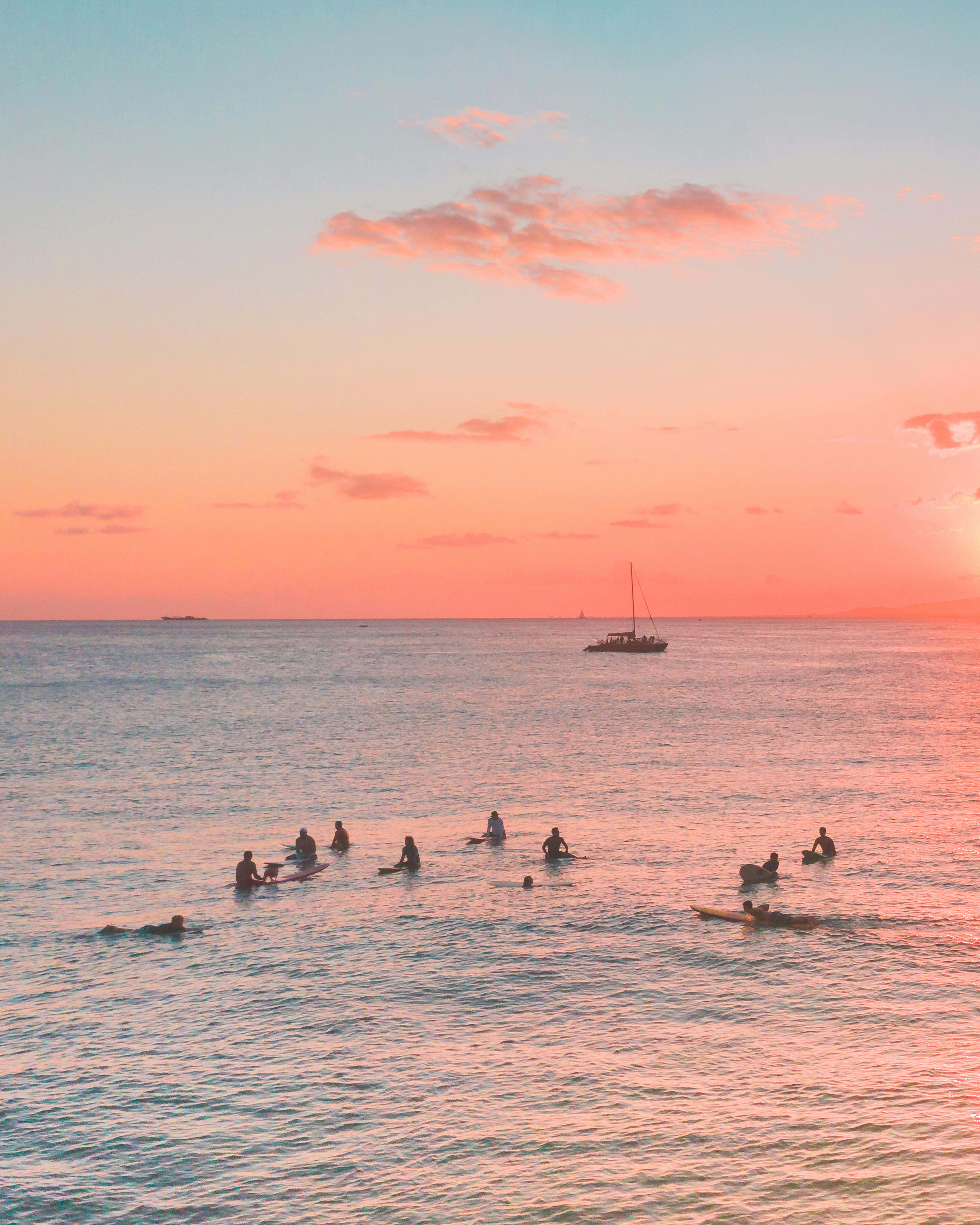 日落时分，冲浪者享受着宁静的大海，捕捉夏夜静谧的精髓