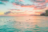 People Surfing on Sea during Sunset