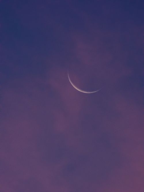 Free A serene view of a crescent moon glowing against a darkening sky, perfect for introspection and tranquility. Stock Photo