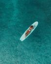 White and Red Surfboard on Green Textile