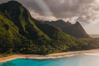 Green and Black Mountain Beside Blue Sea Under White Clouds