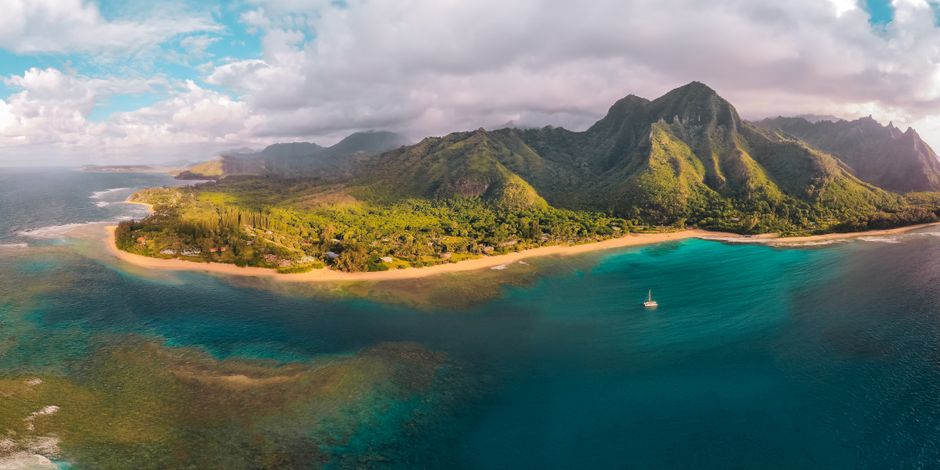 Air Kauai: Ohana (doors-ON) Helicopter Tour - Stunning aerial shot of a coastal landscape with lush mountains and turquoise waters.