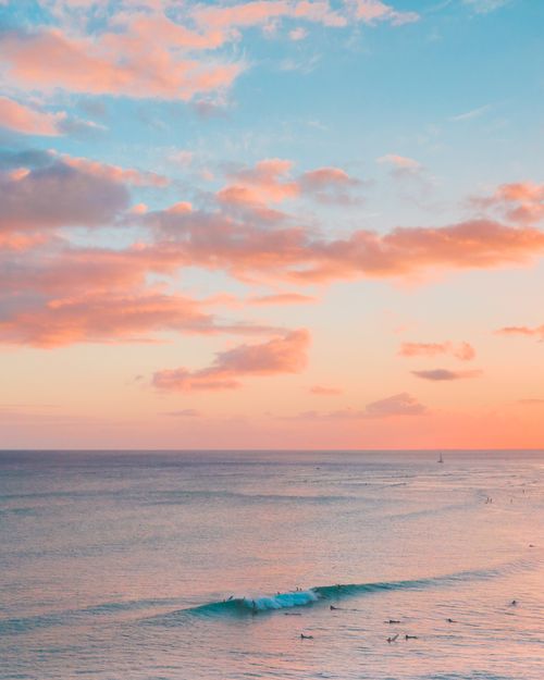 Free A tranquil ocean scene at sunset with pink clouds and gentle waves, perfect for a calming mood. Stock Photo