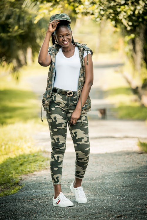 A Happy Woman Posing in a Camouflage Outfit
