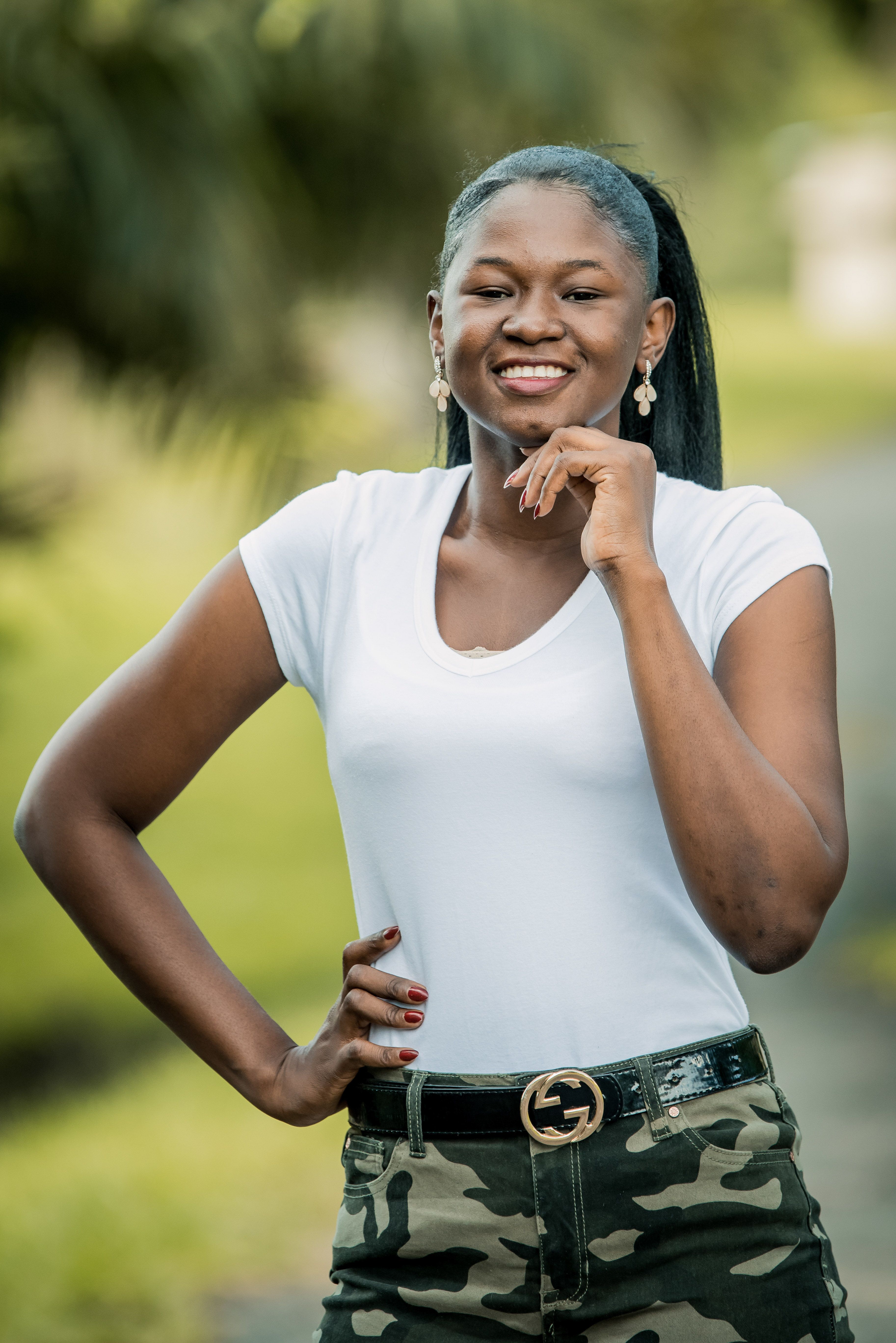 A Woman in a White T Shirt Posing for the Camera · Free Stock Photo