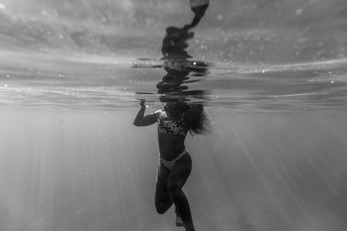 A Woman in a Bikini Swimming Underwater