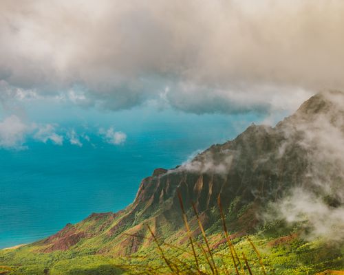 Free Breathtaking view of a mountain range with clouds and ocean, showcasing nature's beauty. Stock Photo