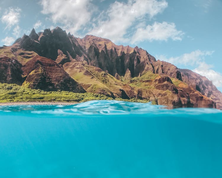 Brown Rock Mountain Near The Blue Body Of Water 