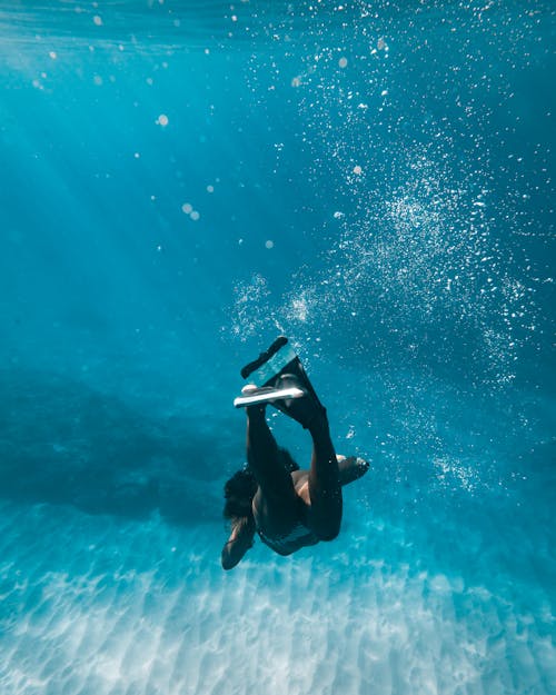 Free Woman in Black Bikini Swimming in the Sea Stock Photo