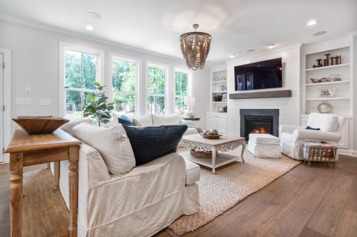 Free Spacious living room with a cozy fireplace, elegant decor, and abundant natural light. Stock Photo