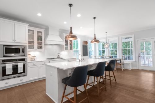 Free Bright and elegant modern kitchen with white cabinets, dining area, and island bar. Stock Photo
