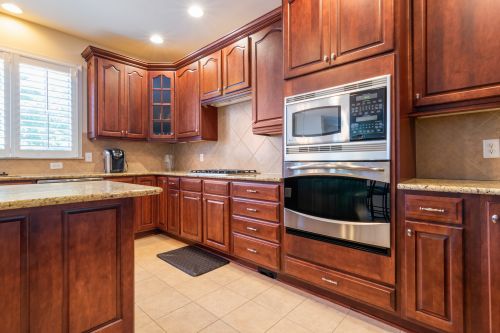 Free Spacious kitchen with wooden cabinetry and built-in appliances. Elegant and functional interior design. Stock Photo