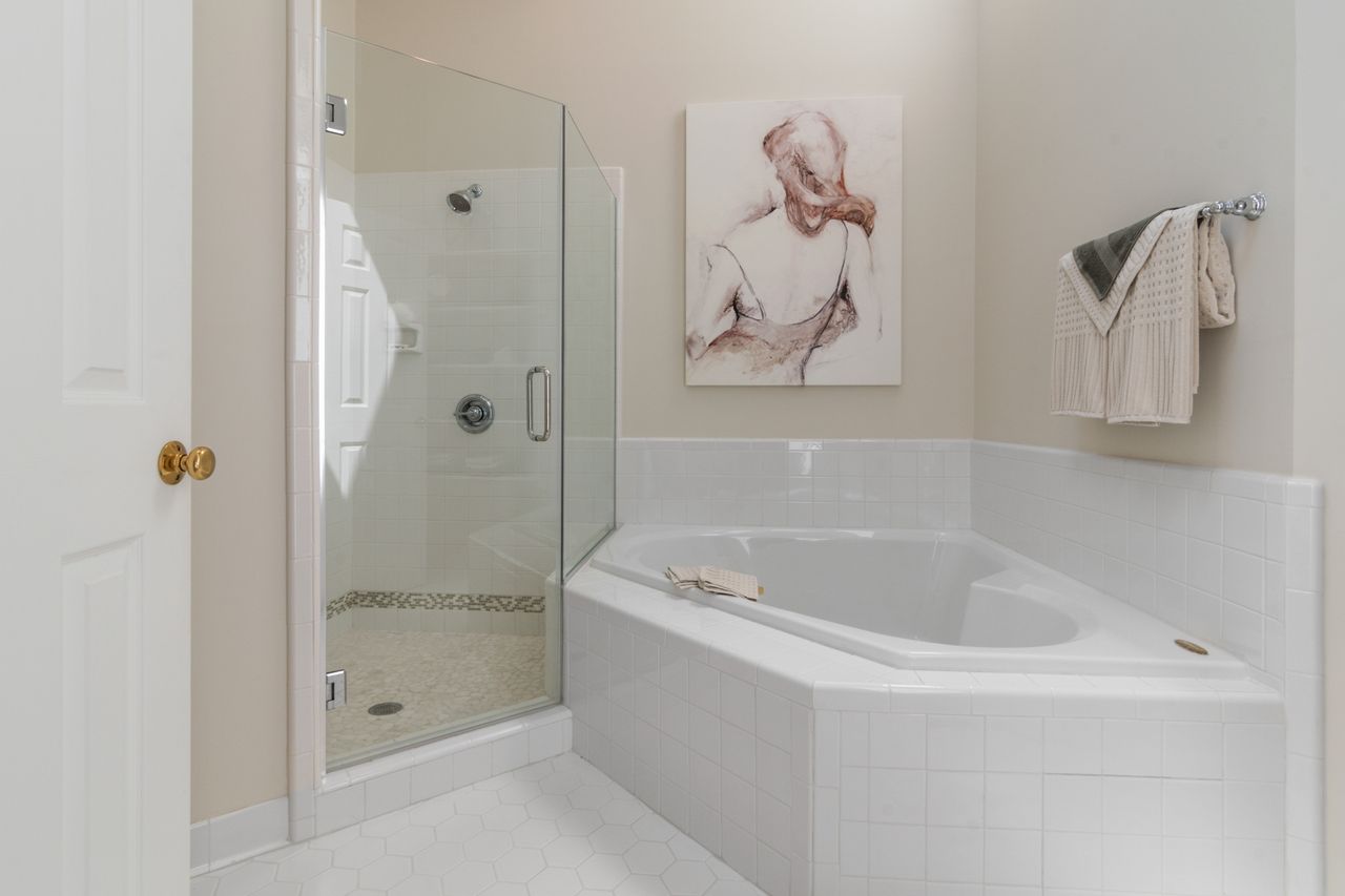 White bathroom with a glass shower door and soaking tub