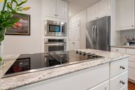 White Wooden Kitchen Cabinet over Stainless Steel Sink