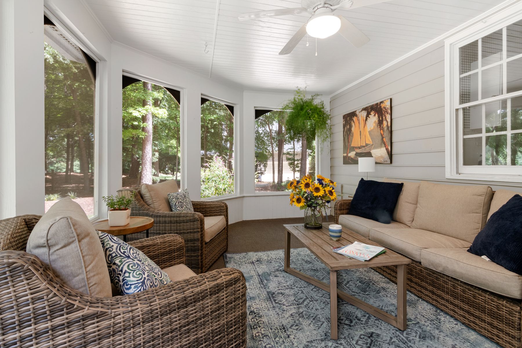 A garden room with glazed walls and a solid insulated ceiling, furnished with wicker seating