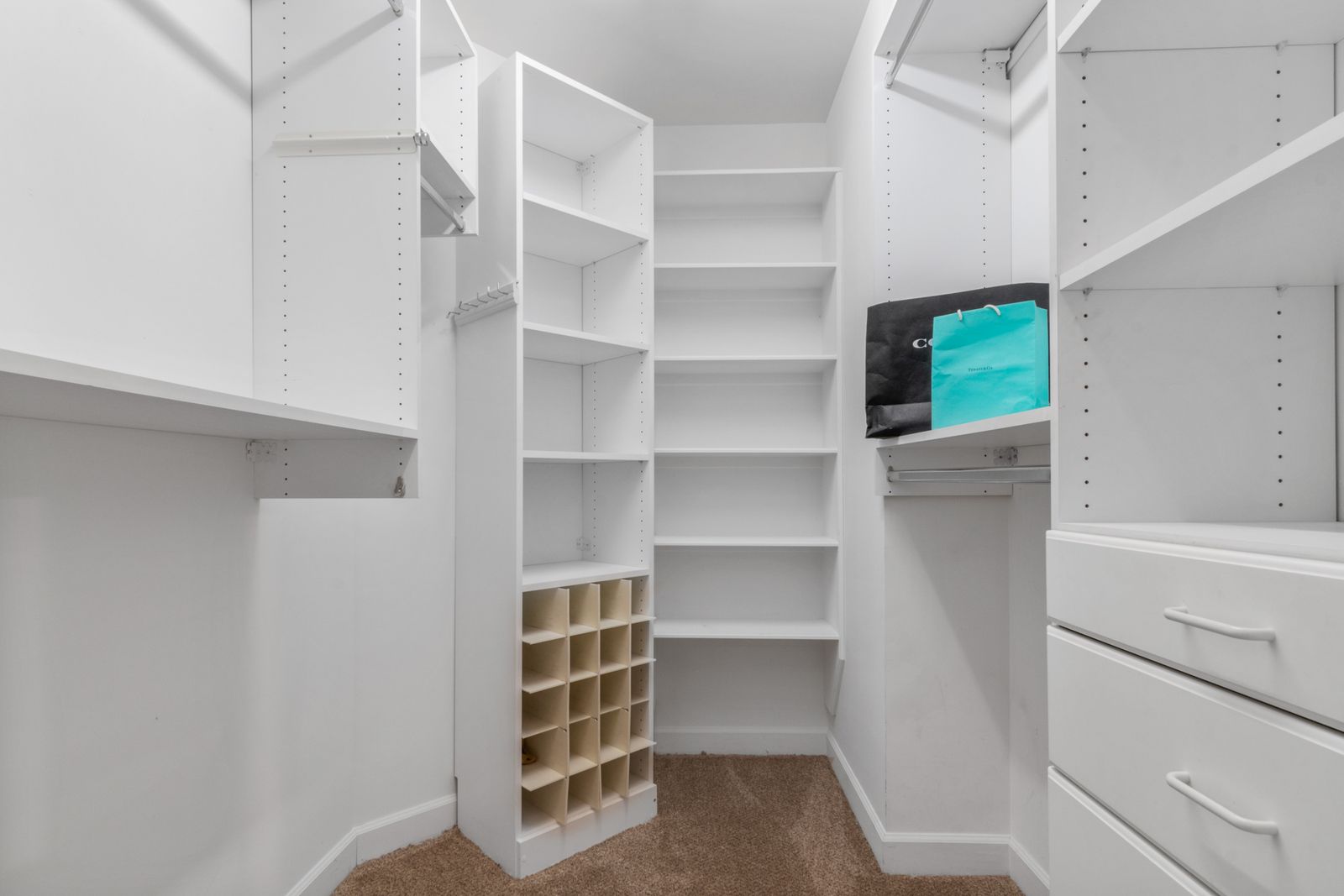 Neatly organized white closet, the kind of clutter-free space professional organizers aim for