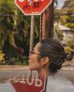 Woman on a City Street in front of a Stop Sign 