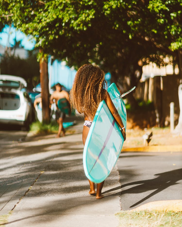 Woman With Surfboard Walking On Street